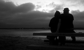 Dark photo of two people on a bench